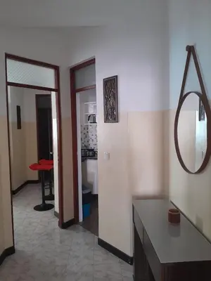 a living room with a table and a mirror at Mindelo Tamba in Mindelo