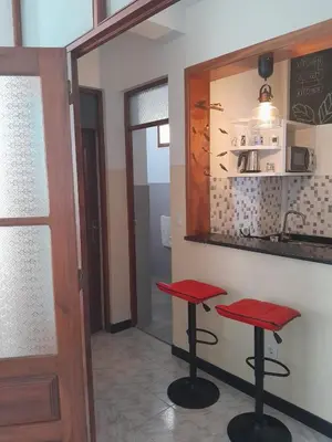 a kitchen with two red stools in front of a counter at Mindelo Tamba in Mindelo
