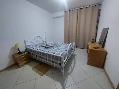 a bedroom with a bed and a desk and a window at SweetLar in Praia
