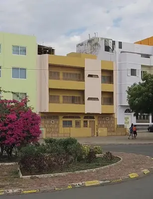 a yellow and white building next to a street at Cozy 3 Bdr at Praia Da Laginha in Mindelo