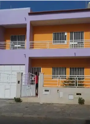 a man standing in the doorway of a building at Maison Praia - Cap Vert in São Filipe