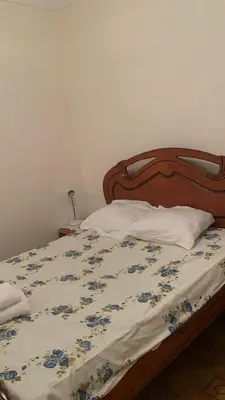 a bed with a blue and white comforter on it at Maison Praia - Cap Vert in São Filipe