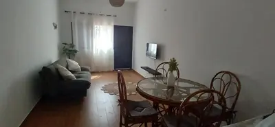 a living room with a glass table and chairs at Cozy Apartment in Praia
