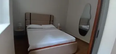 a small bedroom with a white bed and a mirror at Cozy Apartment in Praia