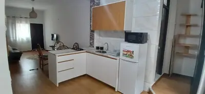 a kitchen with white cabinets and a white refrigerator at Cozy Apartment in Praia