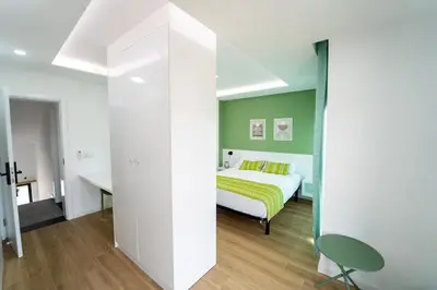 a bedroom with a bed and a green wall at GREEN STUDIO TARRAFAL - Ap 04 in Tarrafal