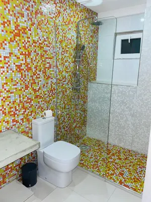 a bathroom with a toilet and a glass shower at Residencial Sol Point Art in Ponta do Sol