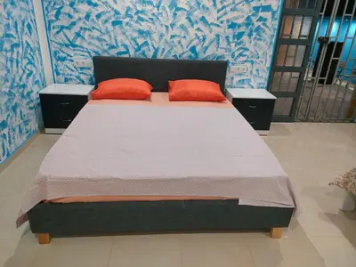 a bed with two orange pillows in a room at Residencial oliveira in Porto Novo