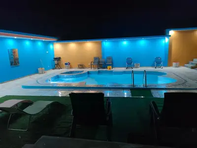 a large swimming pool in a room with blue lights at Residencial oliveira in Porto Novo