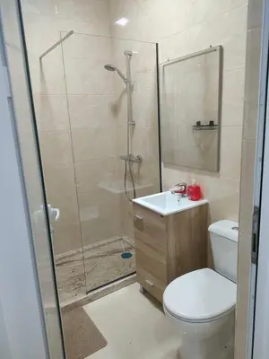 a bathroom with a shower and a toilet and a sink at Residencial oliveira in Porto Novo