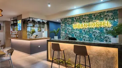 a restaurant with a bar with stools in a lobby at Urban Hostel Mindelo in Mindelo