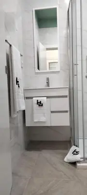 a white bathroom with a sink and a mirror at Urban Hostel Mindelo in Mindelo