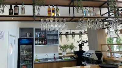 a man standing at a bar with wine glasses at Urban Hostel Mindelo in Mindelo