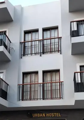 a white building with balconies on the side of it at Urban Hostel Mindelo in Mindelo