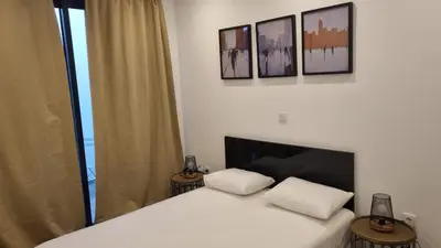 a bedroom with a white bed with three pictures on the wall at Casa Morada in Mindelo