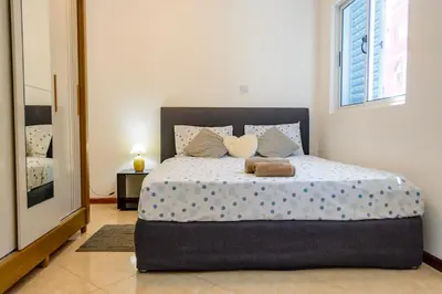 a bedroom with a bed with two pillows and a mirror at Mindelo Dias in Mindelo