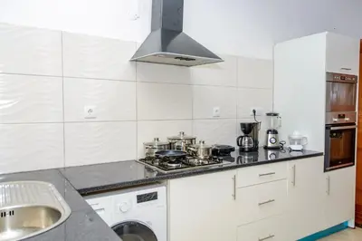 a white kitchen with a stove and a sink at Mindelo Dias in Mindelo