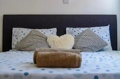 a teddy bear sitting on top of a bed with pillows at Mindelo Dias in Mindelo