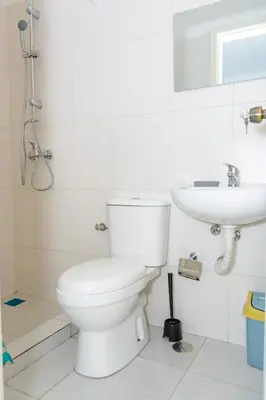 a white bathroom with a toilet and a sink at Mindelo Dias in Mindelo