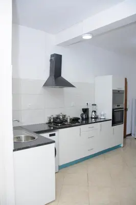 a white kitchen with a sink and a stove at Mindelo Dias in Mindelo