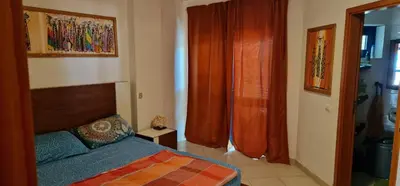 a bedroom with a bed and orange curtains in it at Apartamento em Condominio Privado in Beirona
