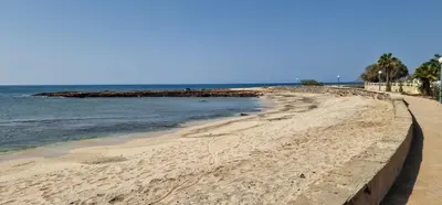 a beach with a retaining wall and the ocean at Apartamento em Condominio Privado in Beirona