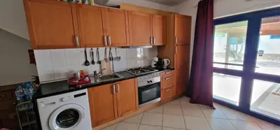 a kitchen with wooden cabinets and a washing machine at Apartamento em Condominio Privado in Beirona