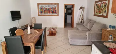 a living room with a table and a couch at Apartamento em Condominio Privado in Beirona