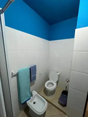 a bathroom with a toilet and a blue ceiling at Tropical Breeze Holidays in Santa Maria