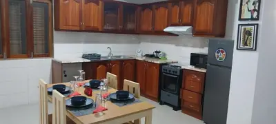 a kitchen with a table with chairs and a refrigerator at Edly aparatments in Mindelo