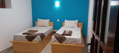 two twin beds in a room with blue walls at Edly aparatments in Mindelo