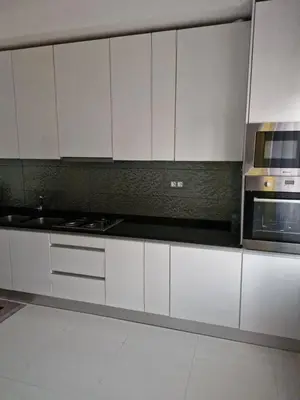 a kitchen with white cabinets and a microwave at Gaudencio Fernandes in Praia