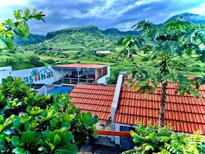 a view of a house with mountains in the background at Paraiso das ilhas in Ribeirão Chiqueiro