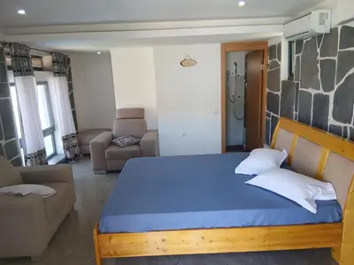 a bedroom with a blue bed and a living room at Paraiso das ilhas in Ribeirão Chiqueiro
