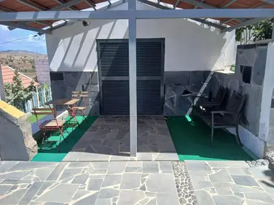 a patio with chairs and a table on a house at Paraiso das ilhas in Ribeirão Chiqueiro