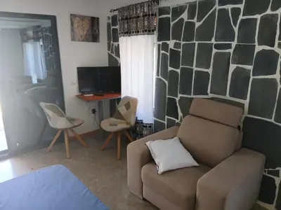 a living room with a couch and a desk at Paraiso das ilhas in Ribeirão Chiqueiro