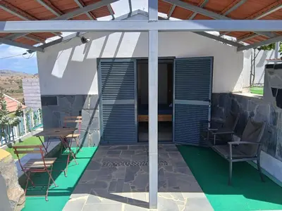 a patio with chairs and a table on a house at Paraiso das ilhas in Ribeirão Chiqueiro
