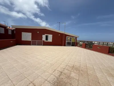a red building with a large parking lot at A Casa do Amor in Vila do Maio