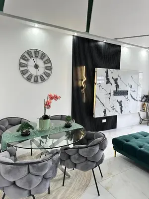 a living room with a glass table and a clock at Belle maison Cosy et Moderne in Praia