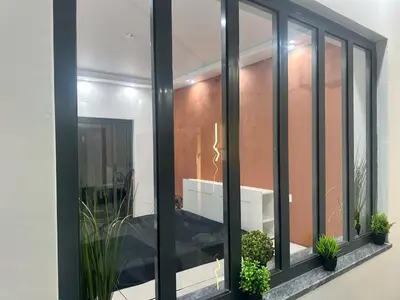 a balcony with black framed windows and potted plants at Belle maison Cosy et Moderne in Praia