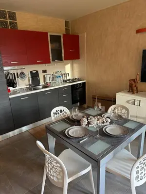 a dining room with a table and chairs and a kitchen at Brisa Meridiana in Santa Maria