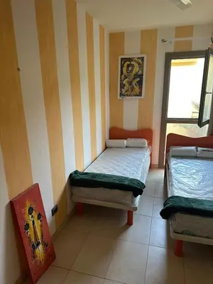 two beds in a room with stripes on the wall at Brisa Meridiana in Santa Maria