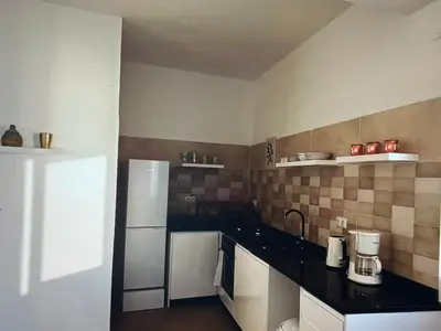 a kitchen with a white refrigerator and black counter tops at The Blue Haven in Sal Rei