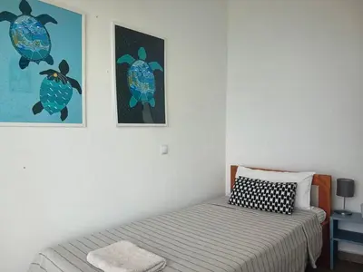 a bedroom with a bed and two pictures on the wall at The Blue Haven in Sal Rei