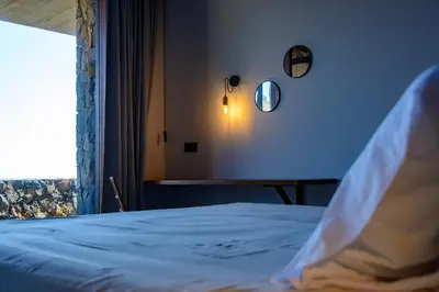 a bedroom with a bed with a window and a table at Casa Vinti9 in Mindelo