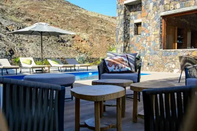 a patio with chairs and tables next to a pool at Casa Vinti9 in Mindelo