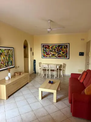a living room with a red couch and a table at Seaside apartment in Shell Beach in Santa Maria