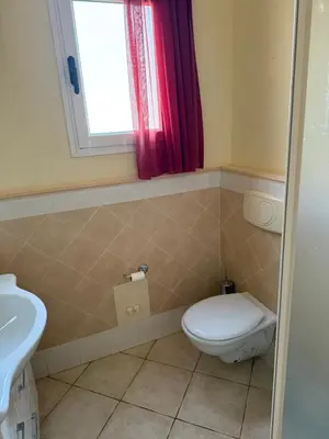 a bathroom with a toilet and a sink and a window at Seaside apartment in Shell Beach in Santa Maria