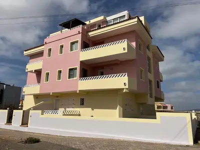 a building with a pink building at Seafront Apartment Shell Beach & Kite Beach Views in Santa Maria