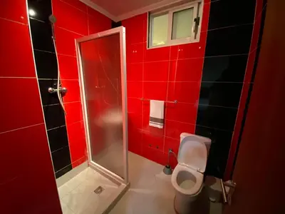 a red bathroom with a toilet and a shower at Pensão Twins Carioca in Tarrafal